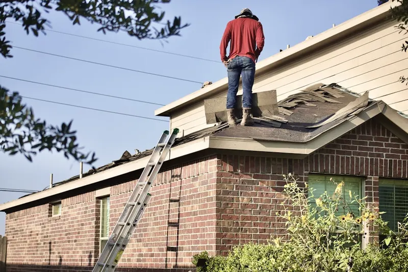 Professional roofer working on a residential roof in Fate